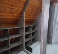 A folding roof of a room with wooden decor and shelves in a cabin.