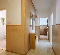 A hallway in a 2-room apartment with wooden paneling and floral decoration on the wall.