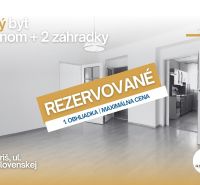 A 2-room apartment with a wooden decor floor and open doors to the kitchen.