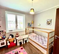 Children's room with a bed, toys, and floor decor in a family house.