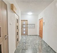 A hallway in a 2-room apartment with tiles and wooden doors.