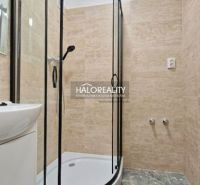 Shower corner in the bathroom of a 2-room apartment with tiles and a sink.