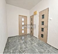 A hallway with a marble floor and doors in a two-room apartment.