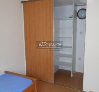 Interior of a 3-room apartment with a bed and built-in wardrobe, floor with wood decor.