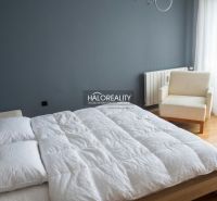A bedroom in a 3-room apartment with a large bed and an armchair.