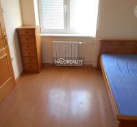 A room in a 3-room apartment with a bed, a dresser, and a floor with a wooden decor.