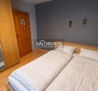 Bedroom in a 3-room apartment with wood-patterned flooring and a large bed.