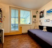 Children's room with a sofa, table, and floor with wood decor in a 3-room apartment.