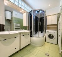 A bathroom in a 3-room apartment with two sinks and a shower.