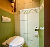 Bathroom in a 3-room apartment with a wall-mounted toilet and light tiles.