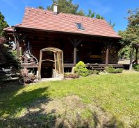 A wooden family house in Devínske Jazero in Bratislava with a lawn and greenery around.