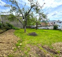 Plots - housing in Lipany with trees and lawn surrounded by buildings and sky.