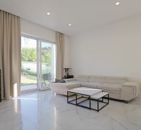 Living room in a family house with a fireplace, sofa, and large windows.