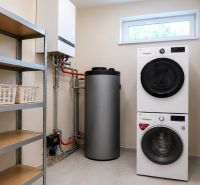 Laundry room in a family house with appliances, a boiler, a shelf, and laundry baskets.