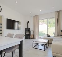Living room in a family house with a television, fireplace, and large window.