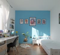 Children's room in a family house with white furniture and a wooden decor floor.