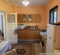 A kitchen in a family house with cabinets and appliances, a floor with a wooden decor.