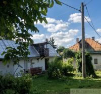 A family house in Štiavnické Bane with a spacious garden and a blue sky full of clouds.