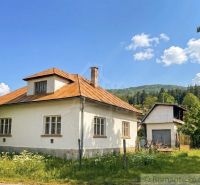 A family house in Štiavnické Bane surrounded by nature and a blue sky.