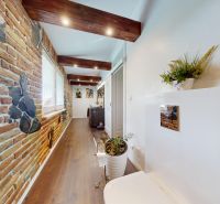 A wall made of bricks and a floor with a wooden decor in a family house.