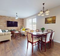 Living room of a family house with a brick wall and a wooden decor floor.