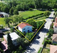 A family house on Zátoňská Street in Malinovo surrounded by greenery and the surrounding buildings.