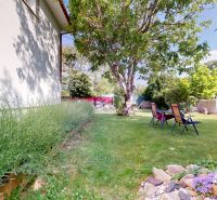 The garden of a family house on Zátoňská Street in Malinovo with a lawn and a swimming pool.