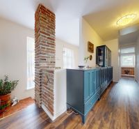 A family house with a wooden decor floor and a blue dresser in the hallway.