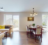 Living room in a family house with ceiling lights and wood-patterned flooring.