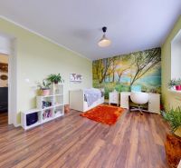 Children's room with wood-patterned flooring, furniture, and natural wallpaper in a family house.