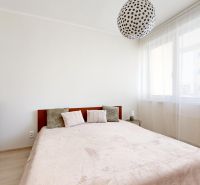 Bedroom with a double bed, dresser, and chandelier in a 3-room apartment.