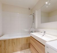 Bathroom in a 3-room apartment with a bathtub, shower, and sink, bright tiles.