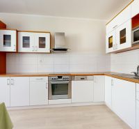 A bright kitchen in a 3-room apartment with white cabinets and wooden decor.