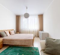 Bedroom in a 3-room apartment with simple furniture and a wooden decor floor.