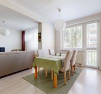 Dining area in a 3-room apartment with a sofa and a wooden decor floor.