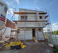 An unfinished family house in Prešov with scaffolding and building materials.