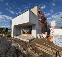A family house under construction in Prešov with an unfinished facade and building materials around.