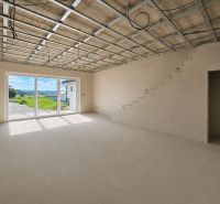 A spacious room in a 5 or more bedroom apartment with a staircase and large windows.