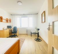 The interior of a room in a 3-room apartment with a wooden decor floor and a desk.