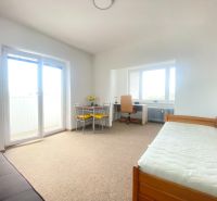 A simple interior of a 3-room apartment with a sofa, table, and bed.