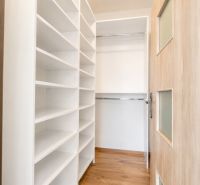 A hallway with built-in shelves and a floor with a wooden decor in a 3-room apartment.