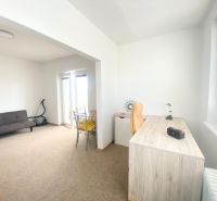 A workspace with a desk, sofa, and balcony door in a 3-room apartment.