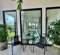 Balcony of a Villa in Bali with a view, plants, and garden furniture.