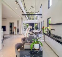 The interior of the villa with a spacious kitchen and dining area, decorated with plants and flowers.