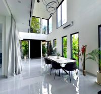 Spacious bright interior of a villa with large windows and modern furniture.
