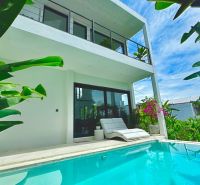 Villa in Bali with a pool and a sunbed, surrounded by exotic greenery.