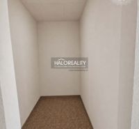 A narrow room with white walls and a floor with a wooden decor in a studio apartment.