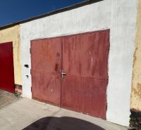 Garages on Vladimíra Roya in Trenčín with red doors and a light facade.