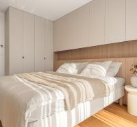 A bedroom with a bed, wardrobes, and a wooden decor floor in a 3-room apartment.