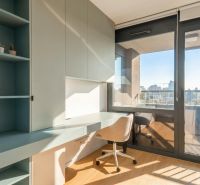 Workspace in a 3-room apartment with wood-patterned flooring and a view of the city.